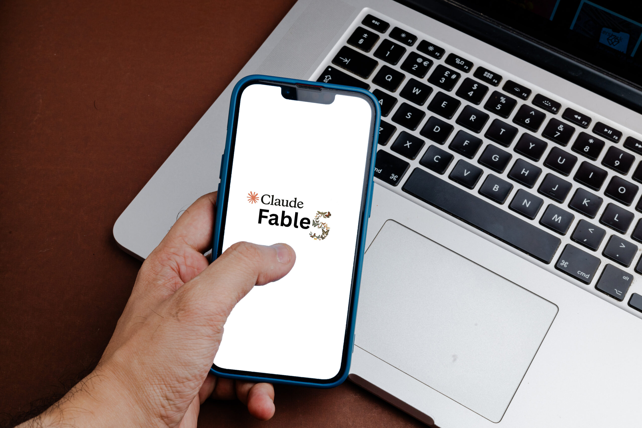 Smartphone displaying the Claude Fable interface next to a laptop, representing AI-assisted storytelling, content creation, and business productivity.